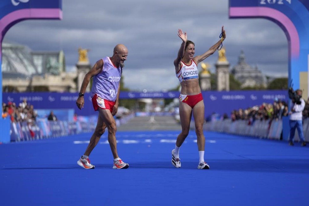 ADDITION ELENA CONGOST WAS DISQUALIFIED FOR LETTING GO OF THE ROPE TO HELP HER GUIDE - Spain's Elena Congost, right, celebrates as she arrives in third position in the women's marathon T12 at the 2024 Paralympics, Sunday, Sept. 8, 2024, in Paris, France. (AP Photo/Thibault Camus)