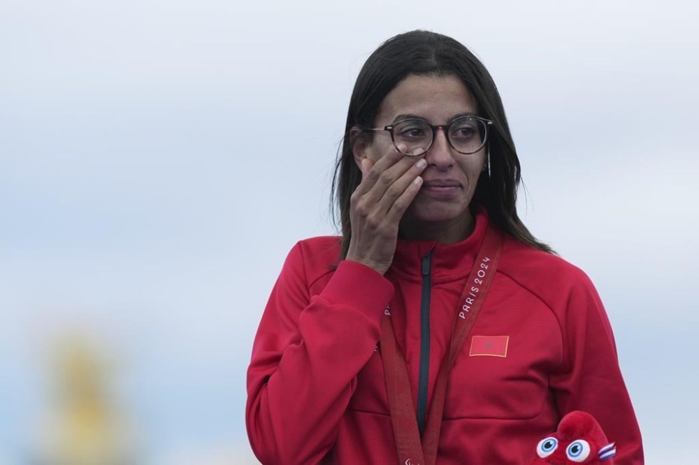 Morocco's Fatima Ezzahra El Idrissi reacts as she stands on the podium with her gold medal after winning the women's marathon T12 at the 2024 Paralympics, Sunday, Sept. 8, 2024, in Paris, France. (AP Photo/Thibault Camus)