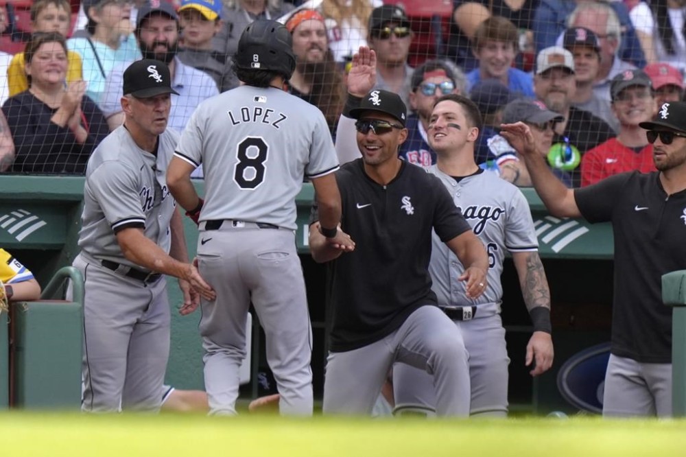 Chicago White Sox's Nicky Lopez (8) is welcomed to the dugout after scoring on a single by Jacob Amaya in the ninth inning of a baseball game against the Boston Red Sox, Sunday, Sept. 8, 2024, in Boston. (AP Photo/Steven Senne)