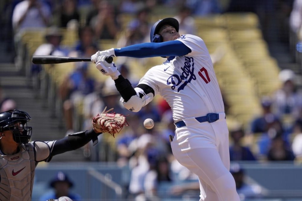 Los Angeles Dodgers' Shohei Ohtani, right, swings for a stake as the ball bounces off of Cleveland Guardians catcher Bo Naylor's mitt during the third inning of a baseball game, Sunday, Sept. 8, 2024, in Los Angeles. (AP Photo/Mark J. Terrill)