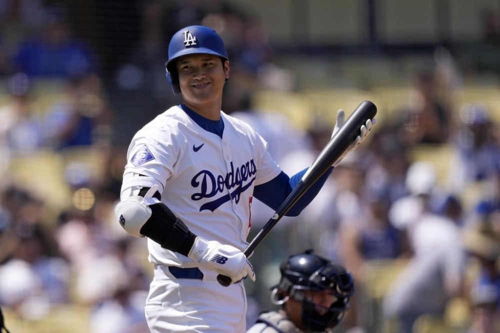 Los Angeles Dodgers' Shohei Ohtani smiles as he looks toward the Cleveland Guardians dugout while stepping up to bat during the first inning of a baseball game, Sunday, Sept. 8, 2024, in Los Angeles. (AP Photo/Mark J. Terrill)