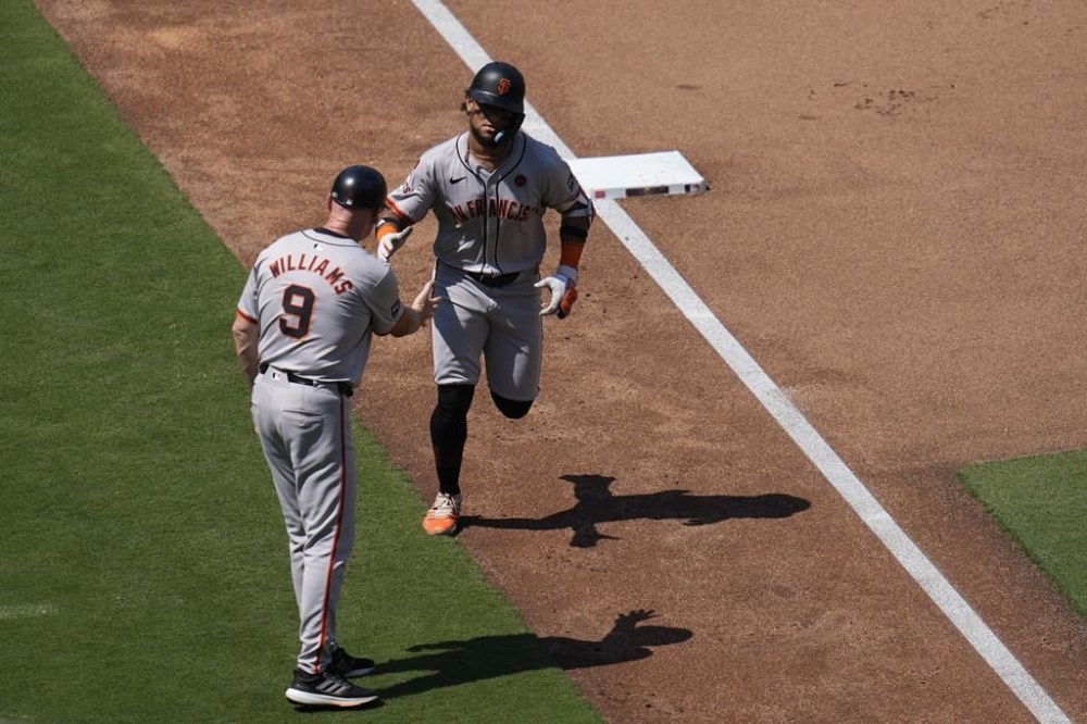 San Francisco Giants' Luis Matos, right, celebrates with third base coach Matt Williams after hitting a home run during the fourth inning of a baseball game against the San Diego Padres, Sunday, Sept. 8, 2024, in San Diego. (AP Photo/Gregory Bull)