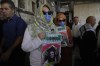 Two fellow activists of Aysenur Ezgi Eygi, 26, who was fatally shot by Israeli soldiers while participating in an anti-settlement protest in the West Bank, carry posters with her name and photo during Eygi's funeral procession in the West Bank city of Nablus, Monday, Sept. 9, 2024. (AP Photo/Nasser Nasser)