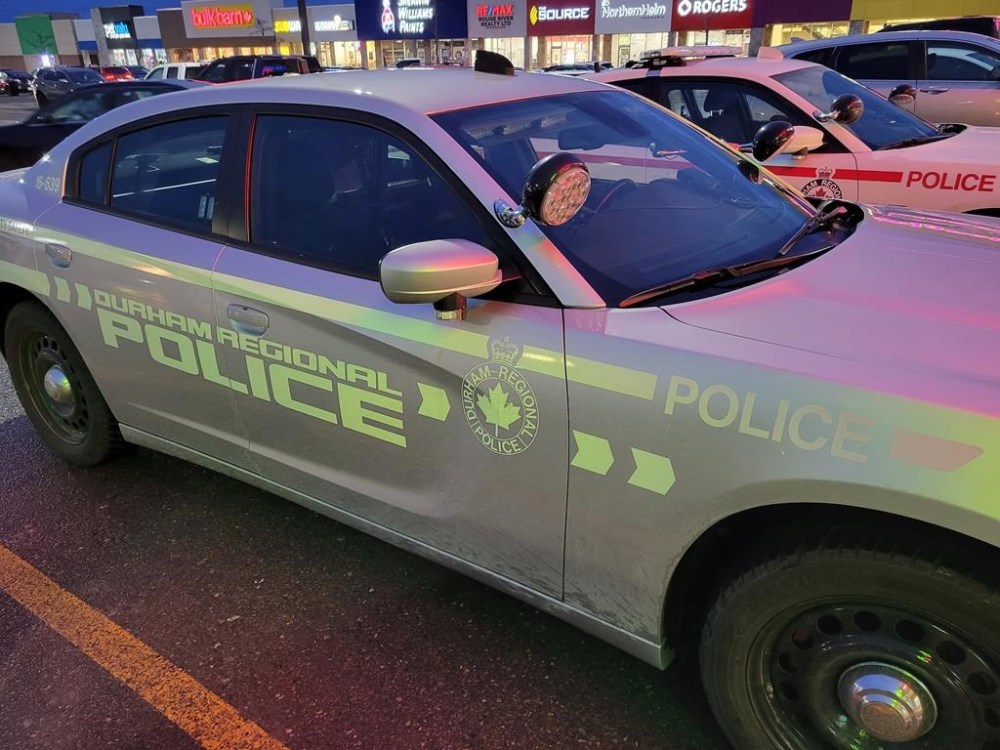 Police in Oshawa, Ont., say a man has been charged in an alleged high-speed fiery crash last month that killed a 41-year-old woman and sent nine other people to hospital. A Durham Regional Police car is shown at a Bowmanville, Ont., shopping centre parking lot on Tuesday, Feb. 28, 2023. THE CANADIAN PRESS/Doug Ives