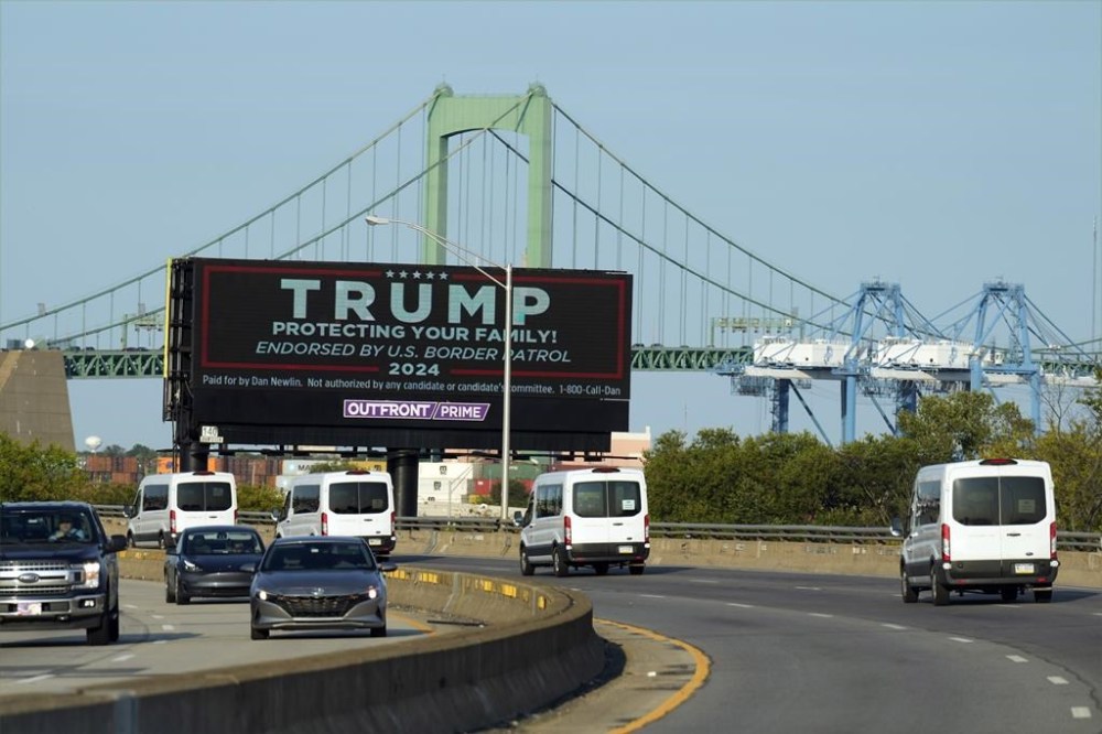 The motorcade of Democratic presidential nominee Vice President Kamala Harris passes a billboard in support of Republican presidential nominee and former president Donald Trump on Monday, Sept. 9, 2024, ahead of the presidential debate in Philadelphia. THE CANADIAN PRESS/AP/Jacquelyn Martin