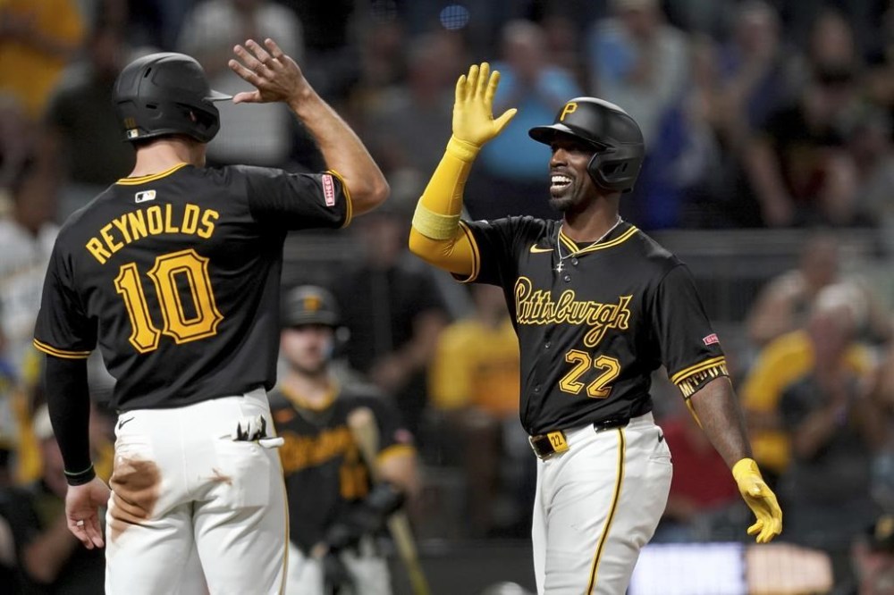 Pittsburgh Pirates' Andrew McCutchen, right, is greeted by Bryan Reynolds, left, after hitting a three-run home run during the fifth inning of a baseball game against the Miami Marlins, Tuesday, Sept. 10, 2024, in Pittsburgh. (AP Photo/Matt Freed)