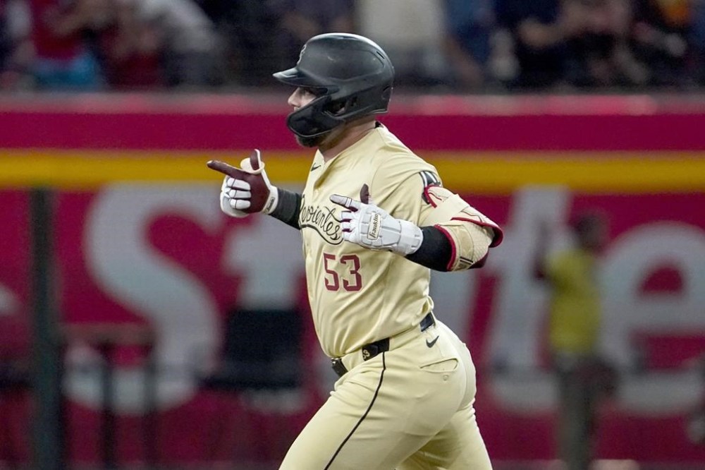 Arizona Diamondbacks' Christian Walker gestures towards his bullpen after hitting a home run against the Texas Rangers during the first inning of a baseball game, Tuesday, Sept. 10, 2024, in Phoenix. (AP Photo/Darryl Webb)