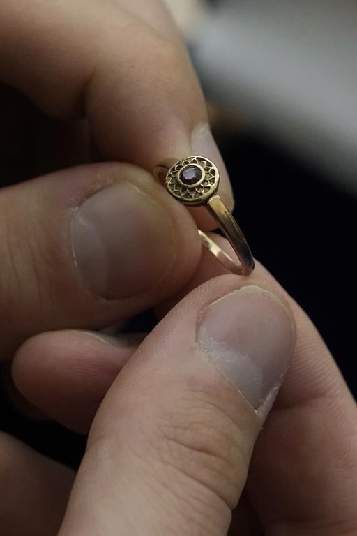 A relative shows a golden ring that was confiscated by Nazi Germans from Zofia Strusińska , who was captured by Nazi troops during Warsaw Uprising in 1944 and taken to a forced labor camp. Her seized items that had been stored at Germany's Arolsen Archives, were returned to Strusińska's relatives in a ceremony in Warsaw, Poland, on Tuesday, Sept. 10, 2024, in which 10 other families also had belongings of their relatives returned.(AP Photo/Czarek Sokolowski)