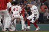 Boston Red Sox's Tyler O'Neill is greeted by teammates at home plate after his game-winning three-run home run in the bottom of the 10th inning of a baseball game against the Baltimore Orioles at Fenway Park, Wednesday, Sept. 11, 2024, in Boston. (AP Photo/Charles Krupa)