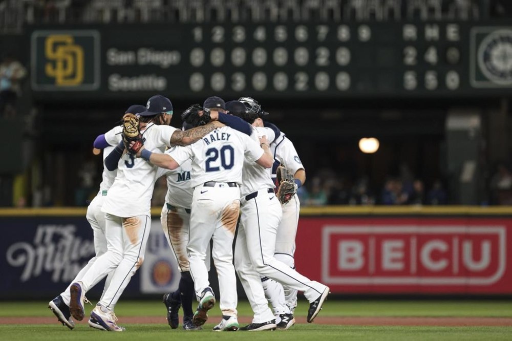 Seattle Mariners players celebrate after defeating the San Diego Padres in a baseball game, Wednesday, Sept. 11, 2024, in Seattle. (AP Photo/Jason Redmond)