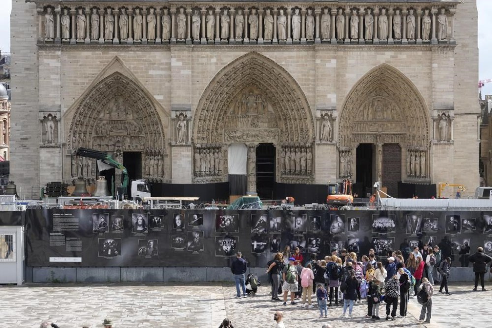 A truck carrying bells, in the background, is parked outside Notre-Dame de Paris cathedral, in Paris, Thursday, Sept. 12, 2024. The Cathedral is getting its bells back, just in time for the medieval landmark's reopening following a devastating 2019 fire. (AP Photo/Michel Euler)