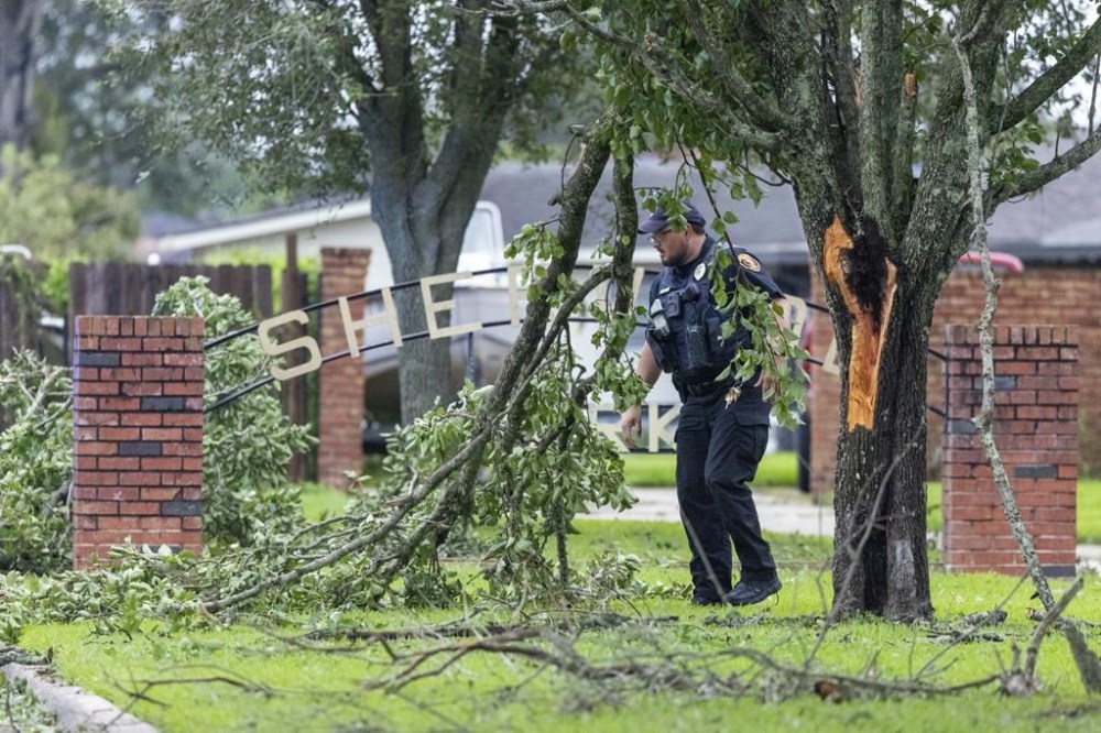 A Houma police officer removes debris from the entrance to a neighborhood in Houma, La., the morning after Hurricane Francine crossed into south Louisiana on Thursday, Sept. 12, 2024. (Chris Granger /The Times-Picayune/The New Orleans Advocate via AP)
