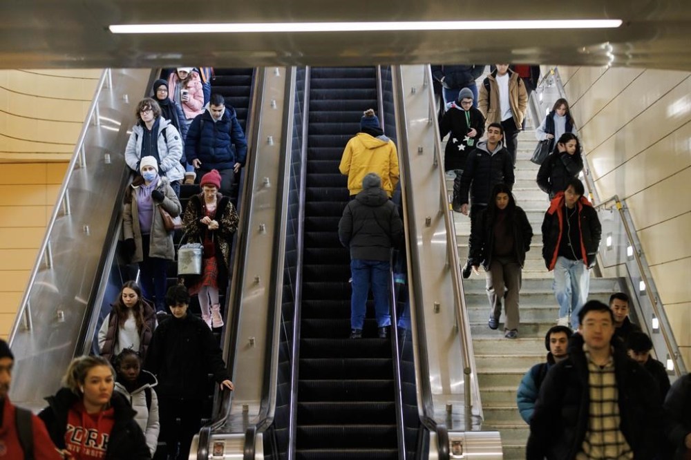 Commuters ride an escalator and walk the stairs at a TTC subway station in Toronto on Monday, Feb. 5, 2024. The TTC is ending free public wi-fi at its subway stations at the end of the year, citing a steep drop in rider usage along with reliability, security and cost concerns. THE CANADIAN PRESS/Cole Burston