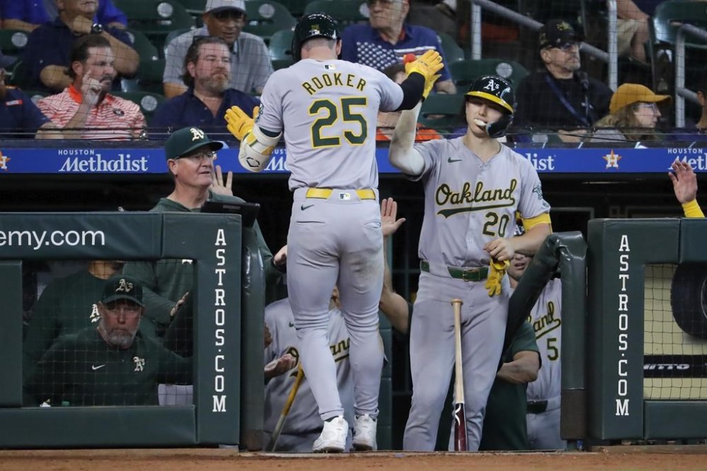 Oakland Athletics designated hitter Brent Rooker (25) high-fives Zack Gelof (20) at the dugout after after hitting a solo home run against the Houston Astros during the eighth inning of a baseball game Thursday, Sept. 12, 2024, in Houston. (AP Photo/Michael Wyke)