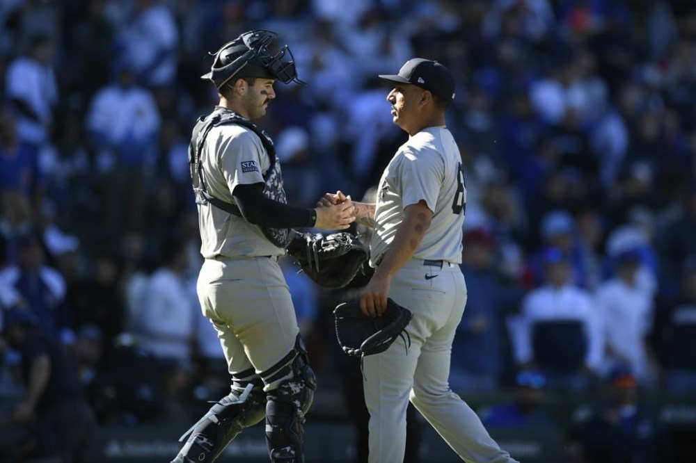 New York Yankees closing pitcher Nestor Cortes, right, celebrates with catcher Austin Wells, left, after defeating the Chicago Cubs 2-0 in a baseball game in Chicago, Saturday, Sept. 7, 2024. (AP Photo/Paul Beaty)