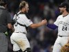 Colorado Rockies third baseman Ryan McMahon, right, congratulates catcher Hunter Goodman after the Rockies victory over the Chicago Cubs in a baseball game, Friday, Sept. 13, 2024, in Denver. (AP Photo/David Zalubowski)