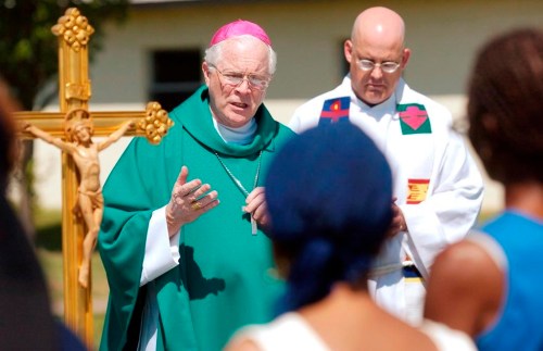 FILE - Edward Slattery, bishop of the Diocese of Tulsa, celebrates Mass in a courtyard for about 30 people Monday, Sept. 5, 2005, at Camp Gruber, in Braggs, Okla. (Jim Beckel/The Oklahoman via AP)