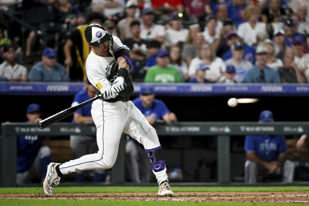 Colorado Rockies' Brenton Doyle hits an RBI sacrifice fly ball in the sixth inning of a baseball game against the Chicago Cubs, Saturday, Sept. 14, 2024, in Denver. (AP Photo/Geneva Heffernan)