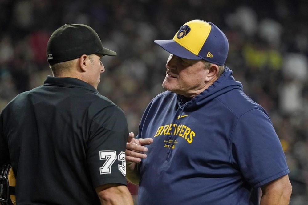 Milwaukee Brewers manager Pat Murphy, right, talks to home plate umpire Tripp Gibson, left, between innings of a baseball game against the Arizona Diamondbacks, Saturday, Sept. 14, 2024, in Phoenix. (AP Photo/Darryl Webb)