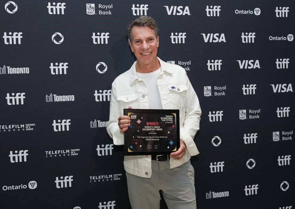 Mike Downie poses for photograph after winning 2024 People's Choice Awards for documentary called