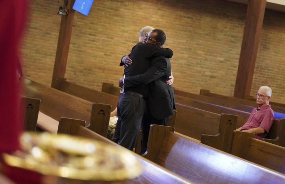 Carl Ruby, pastor at Central Christian Church, hugs Viles Dorsainvil during service, on Sunday, Sept. 15, 2024, in Springfield, Ohio. (AP Photo/Jessie Wardarski)