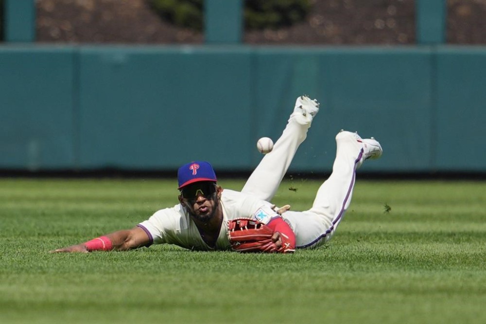 Philadelphia Phillies' Johan Rojas is unable to catch a ball hit by New York Mets' Francisco Lindor during the first inning of a baseball game, Sunday, Sept. 15, 2024, in Philadelphia. (AP Photo/Derik Hamilton)