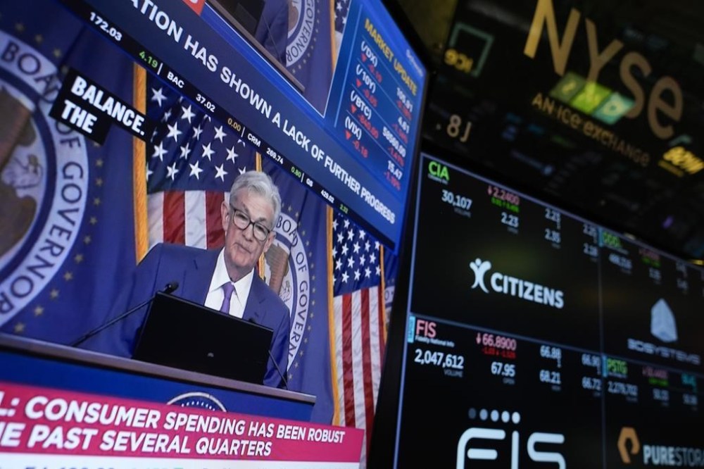 FILE - A screen displays a news conference with Federal Reserve Chairman Jerome Powell on the floor at the New York Stock Exchange in New York, May 1, 2024. (AP Photo/Seth Wenig, File)
