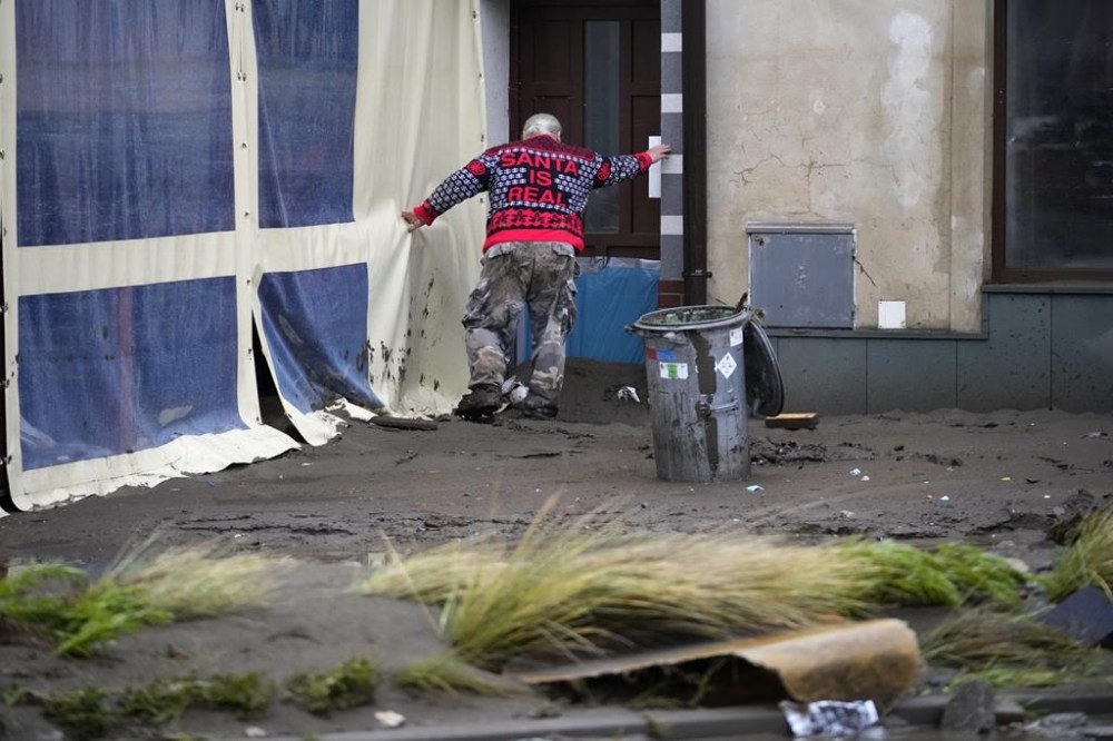 A resident struggles through mud to his house after recent floods in Jesenik, Czech Republic, Monday, Sept. 16, 2024. (AP Photo/Petr David Josek)