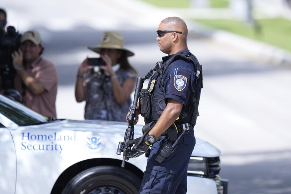 A Department of Homeland Security officer blocks traffic as a prisoner transport van prepares to leave the Paul G. Rogers Federal Building and U.S. Courthouse, where a man suspected in an apparent assassination attempt targeting former President Donald Trump, was charged with federal gun crimes, Monday, Sept. 16, 2024, in West Palm Beach, Fla. (AP Photo/Wilfredo Lee)