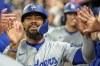 Los Angeles Dodgers' Teoscar Hernández celebrates in the dugout after Freddie Freeman hit a three-run home run in the seventh inning of a baseball game against the Atlanta Braves, Monday, Sept. 16, 2024, in Atlanta. (AP Photo/Jason Allen)