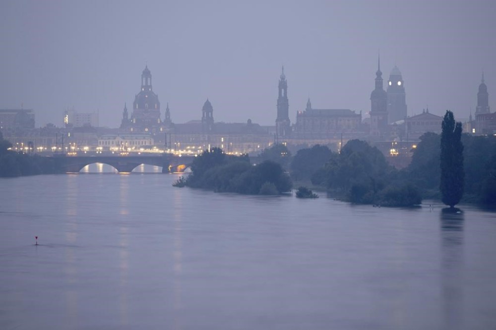 The Elbe floods against the backdrop of the old town at dawn Tuesday, Sept. 17, 2024, in Saxony, Dresden, Germany. (Sebastian Kahnert/dpa via AP)