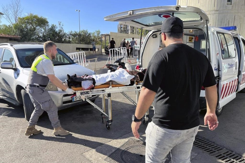 Civil Defense first-responders carry a wounded man whose handheld pager exploded at al-Zahraa hospital in Beirut, Lebanon, Tuesday, Sept. 17, 2024. (AP Photo/Hussein Malla)
