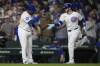 Chicago Cubs' Ian Happ, right, slaps hands with third base coach Willie Harris as he runs the bases on a home run during the third inning of a baseball game against the Oakland Athletics, Tuesday, Sept. 17, 2024, in Chicago. (AP Photo/Erin Hooley)