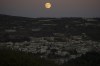 The supermoon rises behind the houses in Mas'ade, a village in the Israeli-annexed Golan Heights, Tuesday, Sept. 17, 2024. (AP Photo/Leo Correa)