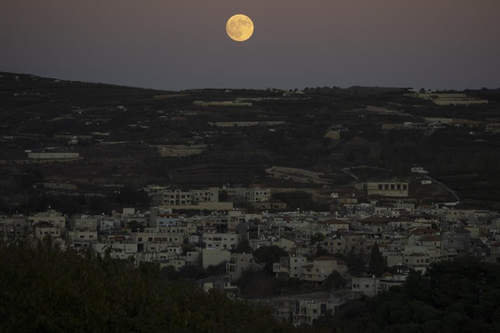 The supermoon rises behind the houses in Mas'ade, a village in the Israeli-annexed Golan Heights, Tuesday, Sept. 17, 2024. (AP Photo/Leo Correa)