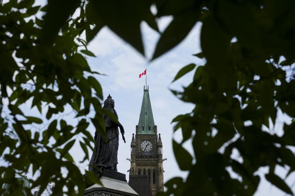 The Liberal government says it is further cutting the number of permits it issues to international students who come to Canada to study. The Peace Tower on Parliament Hill is framed by leaves in Ottawa on Tuesday, Aug. 27, 2024. THE CANADIAN PRESS/Sean Kilpatrick