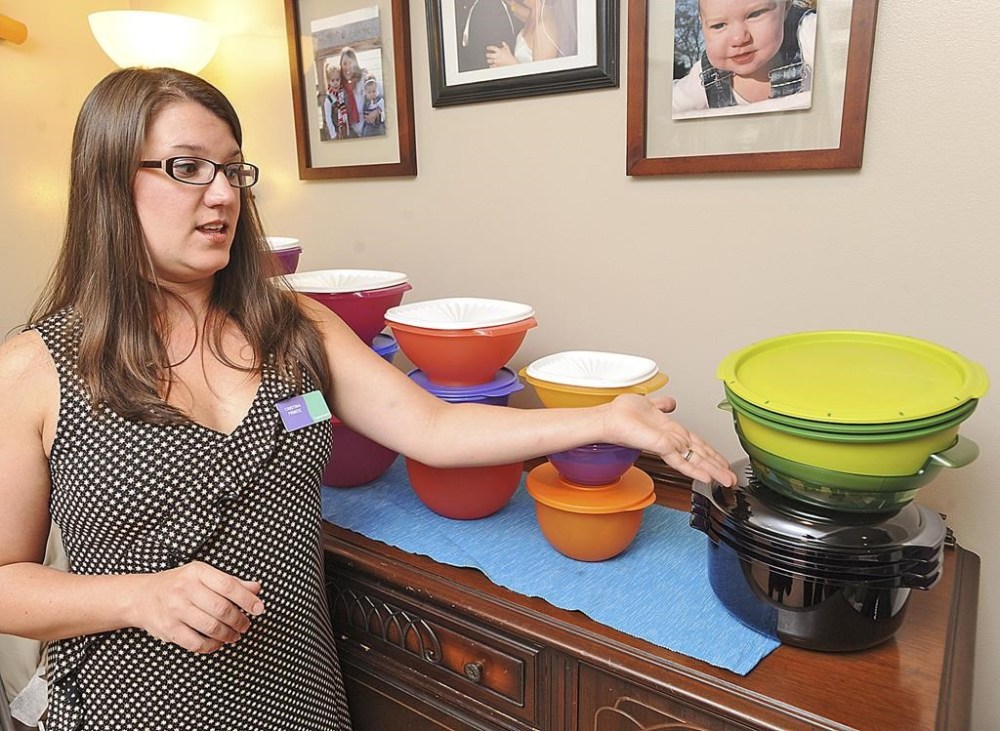 FILE - Cristina Prince, a Severna Park Elementary School teacher and a Tupperware consultant, shows off some of her merchandise on Aug. 18, 2011. (AP Photo/The Capital, Joshua McKerrow, File)