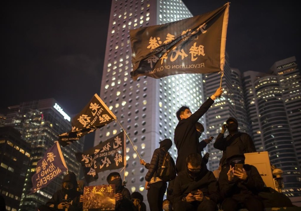 FILE - A protestor holds a flag that reads: