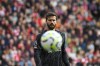 Liverpool's goalkeeper Alisson looks the ball during the English Premier League soccer match between Liverpool and Nottingham Forest at Anfield Stadium in Liverpool, England, Saturday, Sept. 14, 2024. (AP Photo/Rui Vieira)