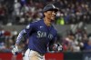 Seattle Mariners' Julio Rodriguez reacts toward the dugout as he runs the bases after hitting a two-run home run against the Texas Rangers in the seventh inning, Friday, Sept. 20, 2024, in Arlington, Texas. (AP Photo/Richard W. Rodriguez)