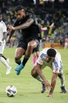 Nashville SC midfielder Anibal Godoy, left, leaps over FC Cincinnati defender Miles Robinson, right, as they chase the ball during the second half of an MLS soccer match Saturday, Sept. 21, 2024, in Nashville, Tenn. (AP Photo/George Walker IV)