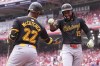 Pittsburgh Pirates' Oneil Cruz, right, is congratulated by Andrew McCutchen, left, after hitting a solo home run in the first inning of a baseball game against the Cincinnati Reds, Sunday, Sept. 22, 2024, in Cincinnati. (AP Photo/Kareem Elgazzar)