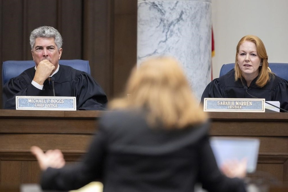 Georgia Supreme Court Chief Justice Michael Boggs and Justice Sarah Warren listen to oral arguments from attorney Elizabeth Young, representing the Secretary of State, at the Supreme Court in Atlanta on Tuesday, Sept. 24, 2024. (Arvin Temkar/Atlanta Journal-Constitution via AP)