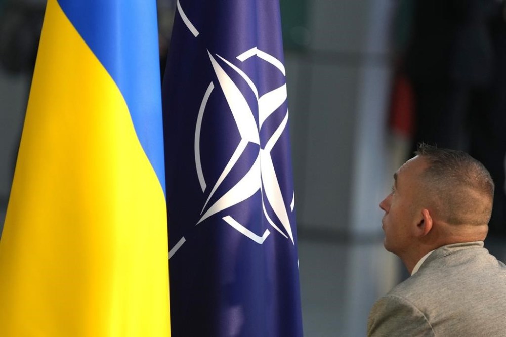 FILE - A member of protocol sets up the NATO and Ukrainian flags prior to a media conference of Ukraine's President Volodymyr Zelenskyy and NATO Secretary General Jens Stoltenberg during a meeting of NATO defense ministers at NATO headquarters in Brussels, Wednesday, Oct. 11, 2023. (AP Photo/Virginia Mayo, File)