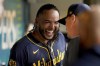 Milwaukee Brewers starter Freddy Peralta celebrates in the dugout after getting his 200th strikeout of the season during the sixth inning of a baseball game against the Pittsburgh Pirates, Wednesday, Sept. 25, 2024, in Pittsburgh. (AP Photo/Matt Freed)