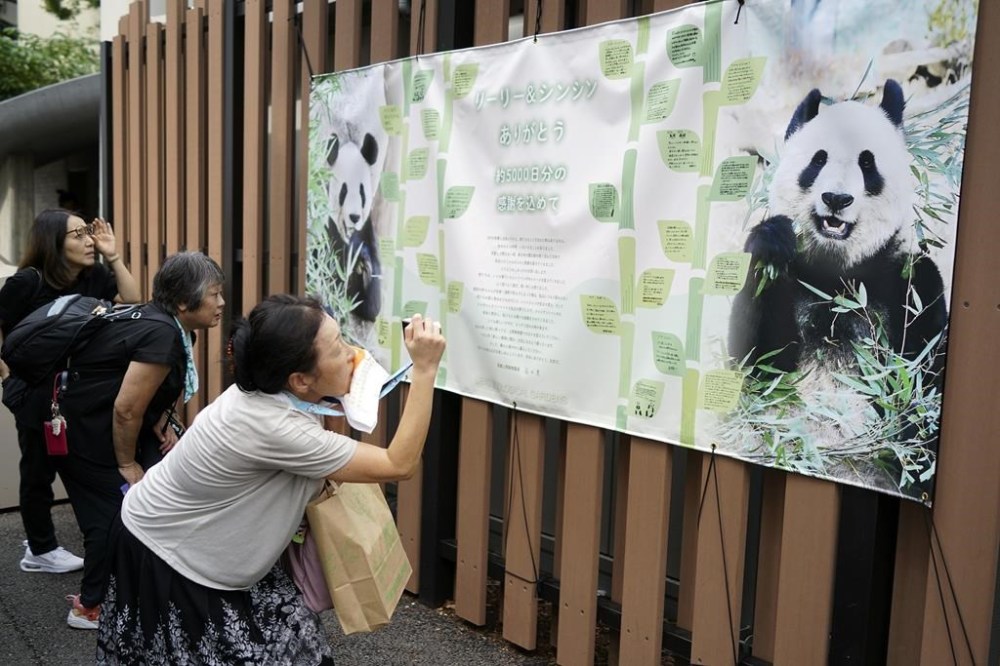 Visitors take a look at a banner saying