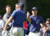 United States team member Collin Morikawa shakes hands with partner Scottie Scheffler as International team member Adam Scott of Australia,left, looks after winning their third round four-ball match at the Presidents Cup golf tournament at Royal Montreal Golf Club in Montreal Saturday, Sept. 28, 2024. THE CANADIAN PRESS/Nathan Denette