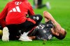 Munich's Harry Kane gets assistance as he lies on the pitch during the German Bundesliga soccer match between Bayern Munich and Leverkusen at the Allianz Arena in Munich, Germany, Saturday, Sept. 28, 2024. (Sven Hoppe/dpa via AP)