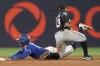 Toronto Blue Jays' George Springer steals second base in front of Miami Marlins shortstop Xavier Edwards during third inning interleague MLB baseball action in Toronto, Saturday, Sept. 28, 2024. THE CANADIAN PRESS/Chris Young