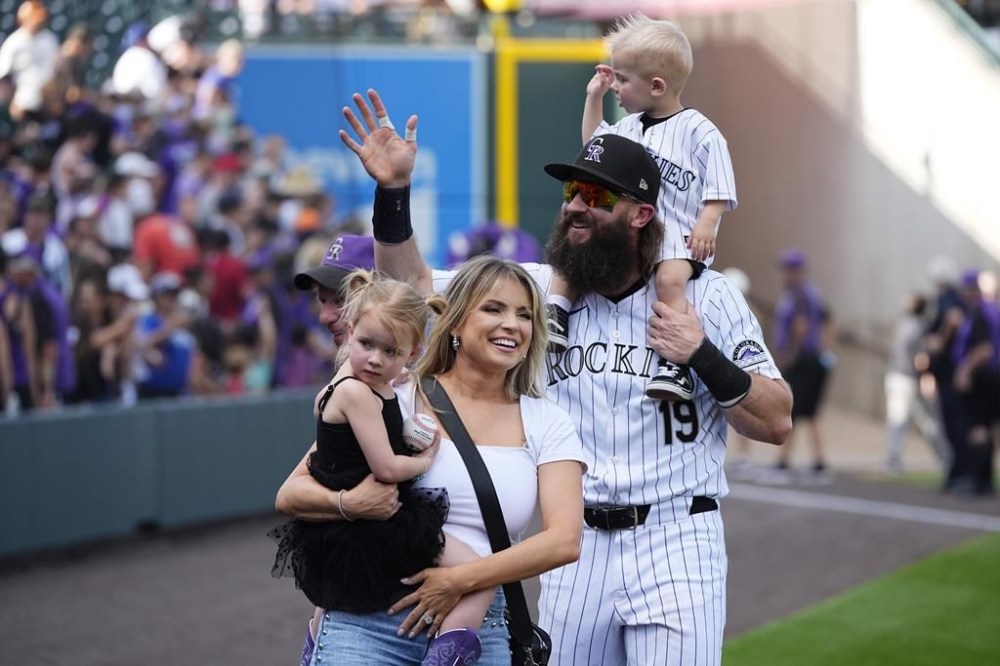 Retiring Colorado Rockies outfielder Charlie Blackmon, right, thanks fans alongside wife Ashley and children Josie and Wyatt during the team's ceremonial walk around the field following a loss in the season finale, Sunday, Sept. 29, 2024, in Denver. (AP Photo/David Zalubowski)